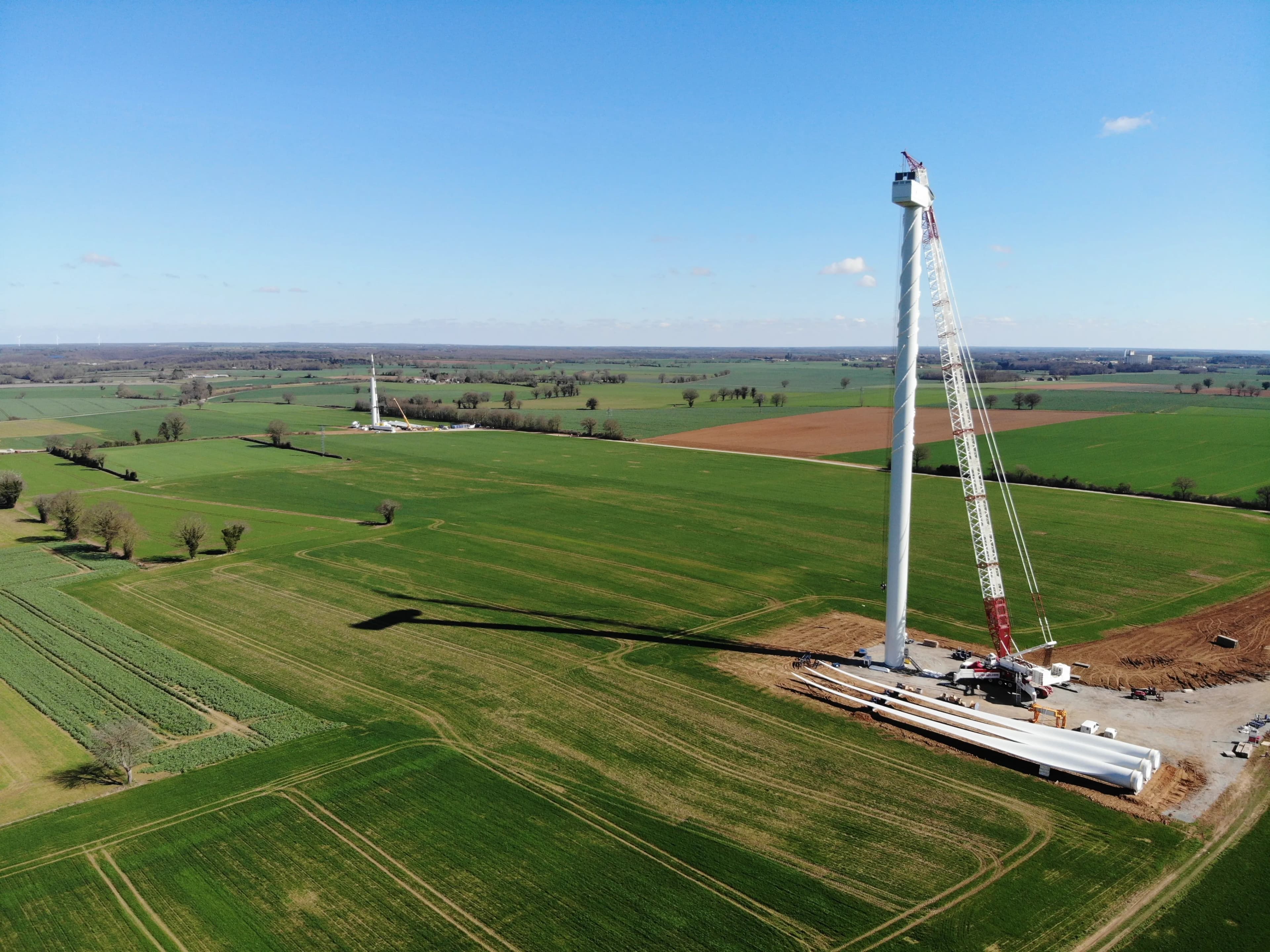 A wind turbine under construction from a distance
