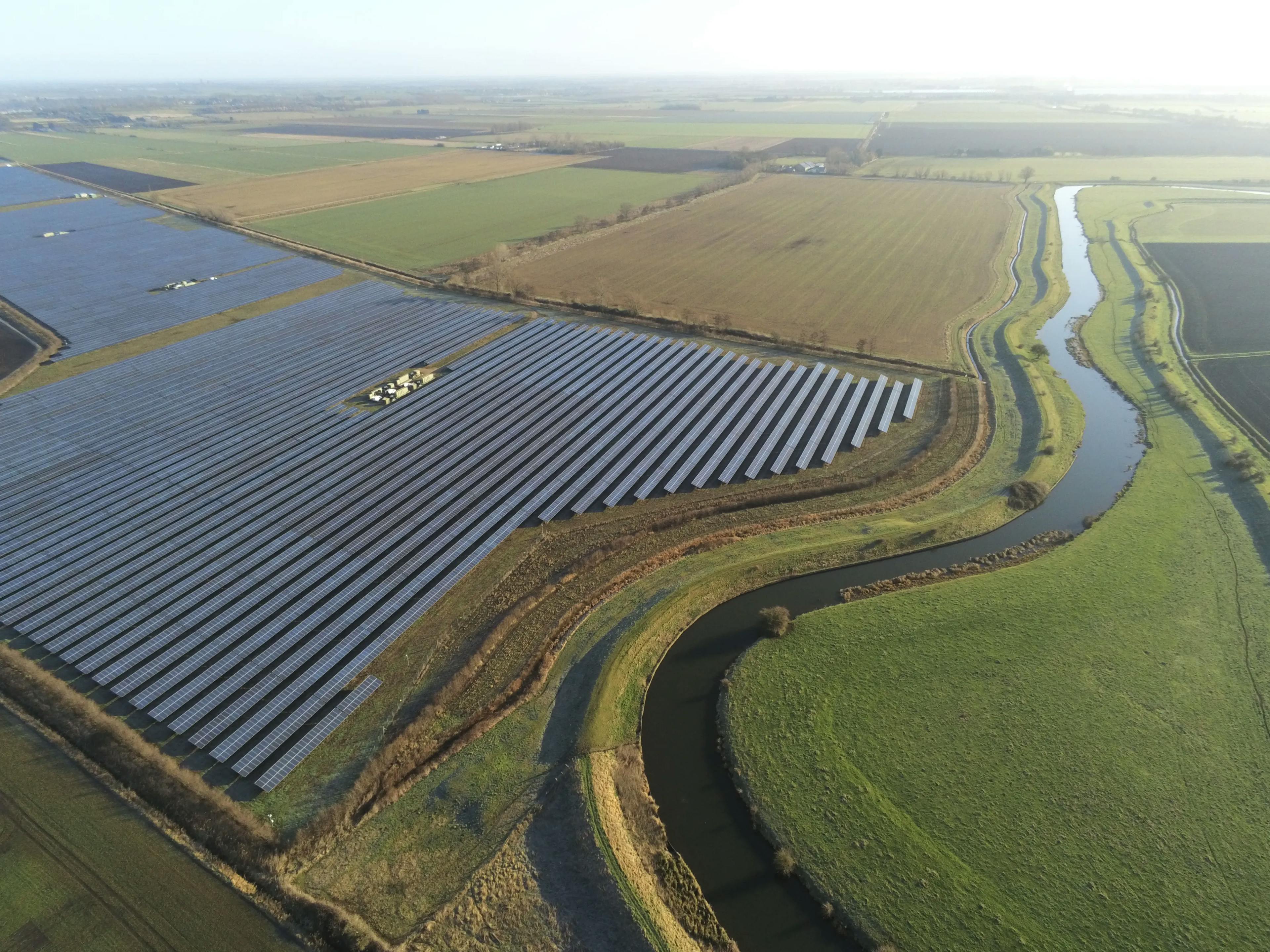 A solar farm by a river, taken from a height